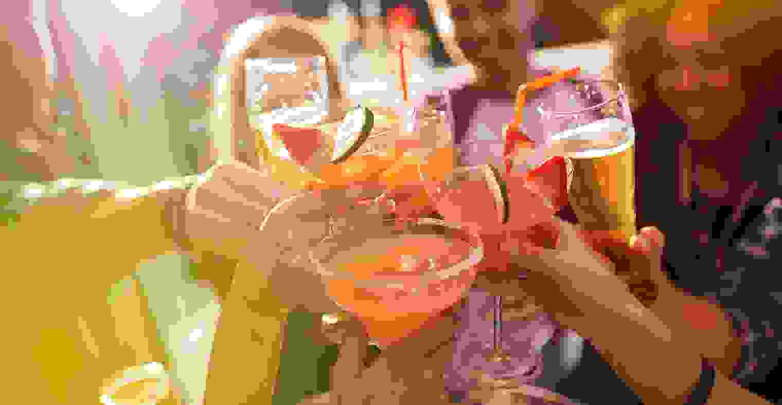 A group of people toasting with their drinks at a nightclub