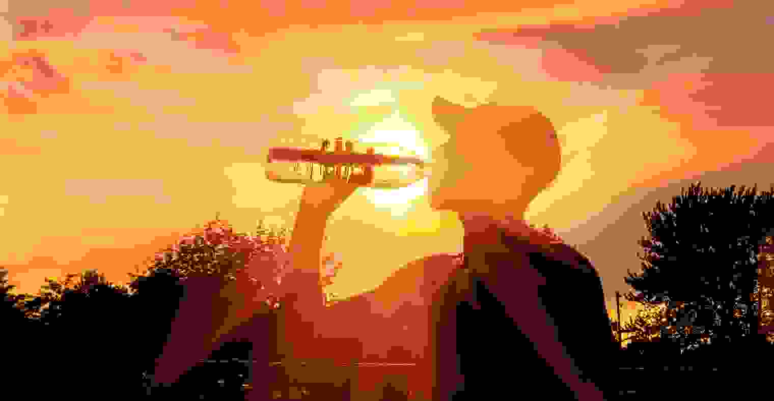 Silhouette of a man drinking water during a heat wave