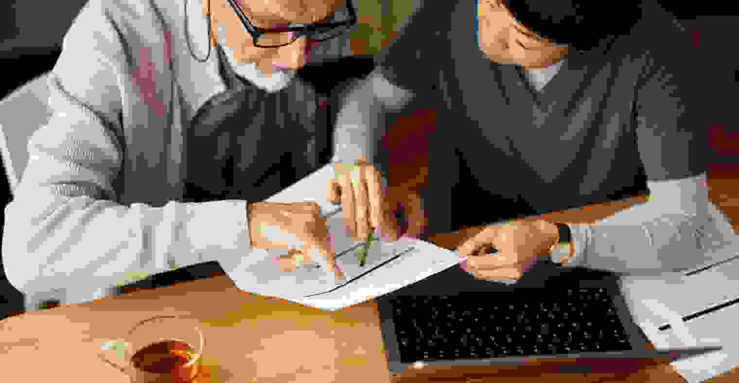 A senior man reviewing paperwork with a nurse