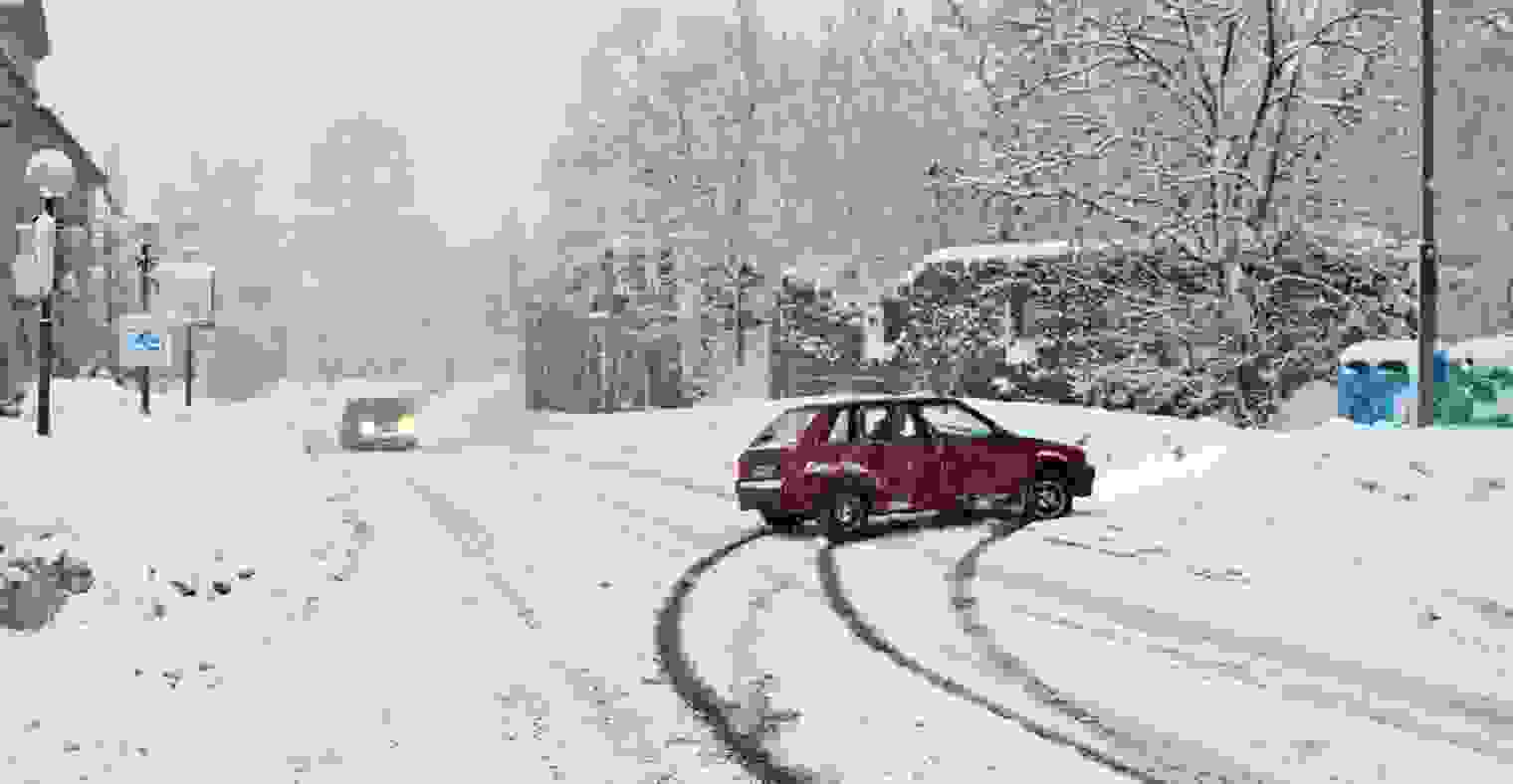 Car slides into snow bank