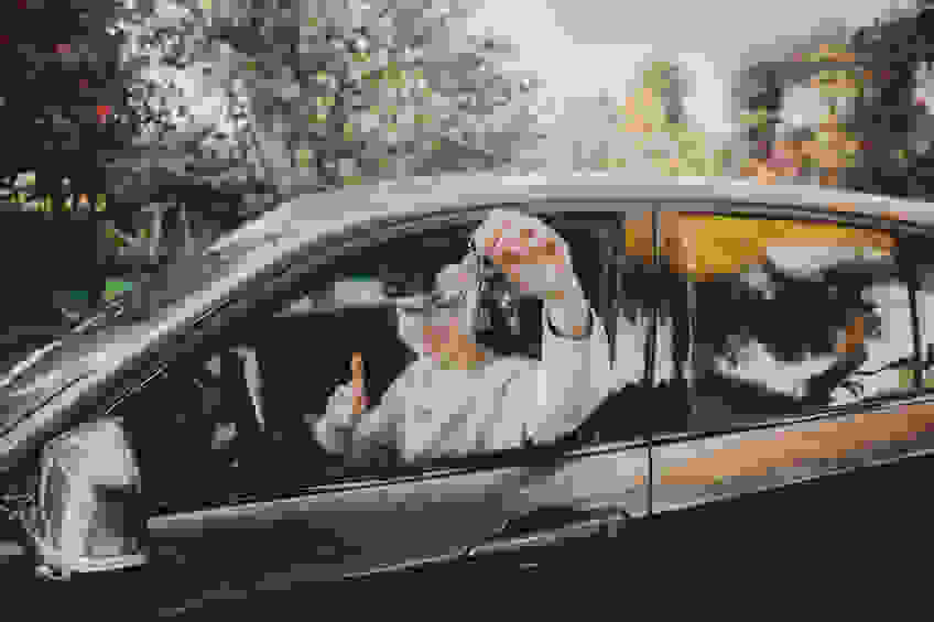 A young driver sits in his car.