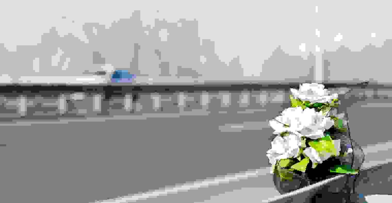 White roses at the site of a fatal car crash.