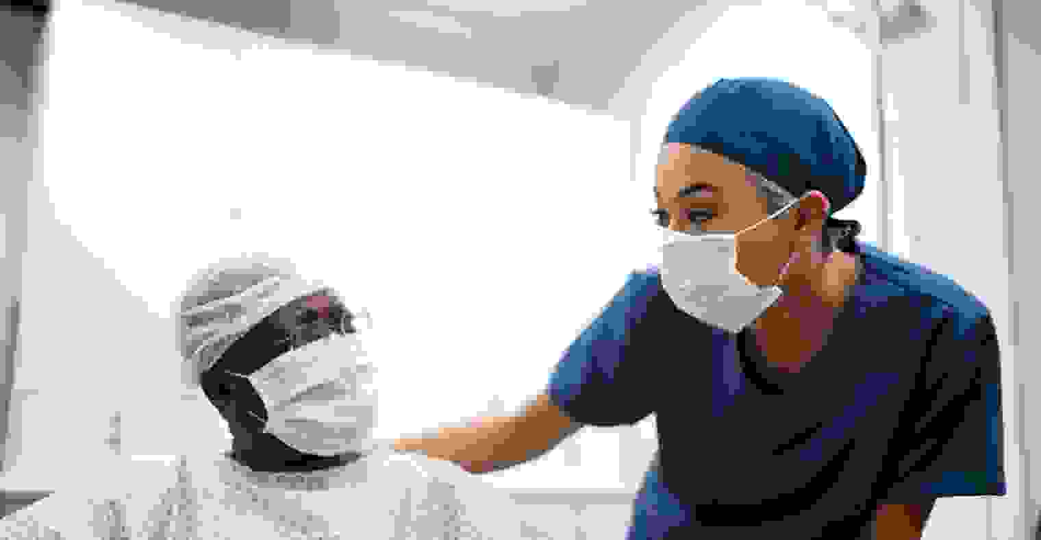 A nurse talking to a patient.