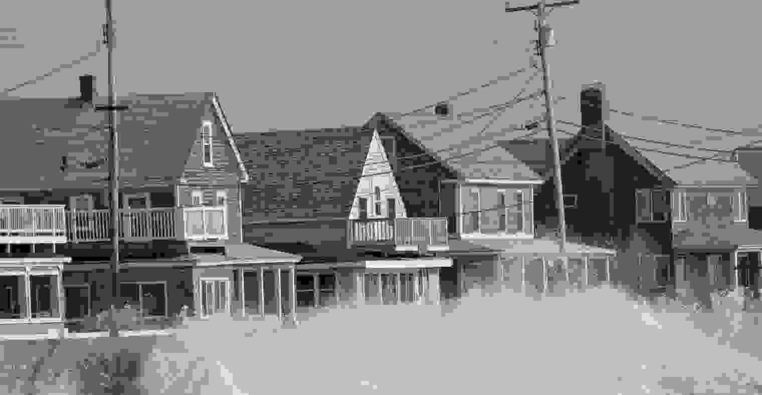 Waves strike a seawall protecting some coastal homes