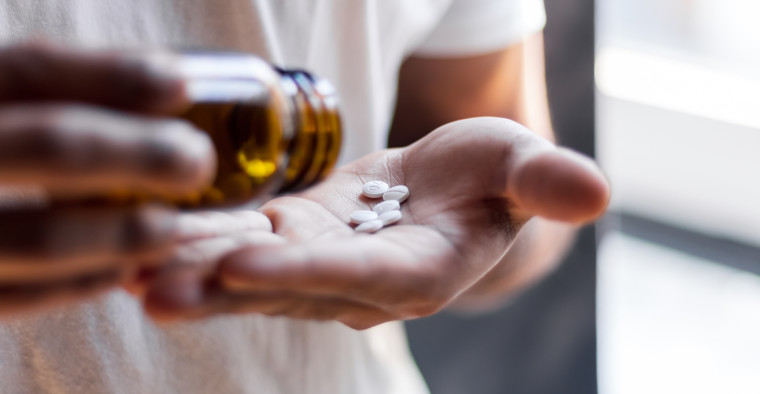 A person counting out their pills