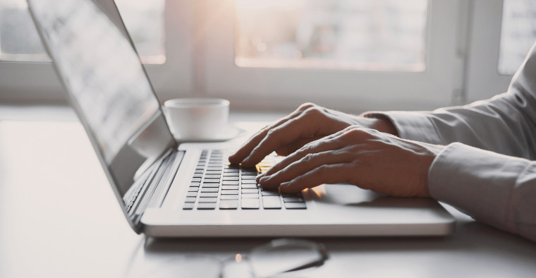 person typing business plan on laptop