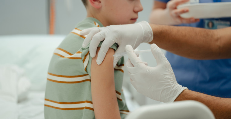 Child receives vaccine from doctor