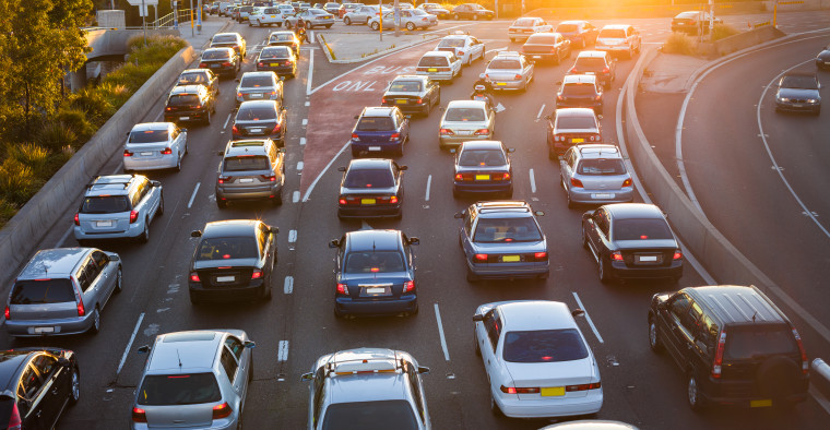 Cars driving on freeway at sunset