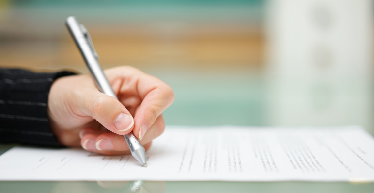 person signing car loan document