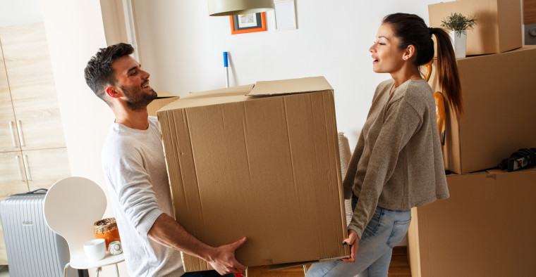 couple carrying property into new home