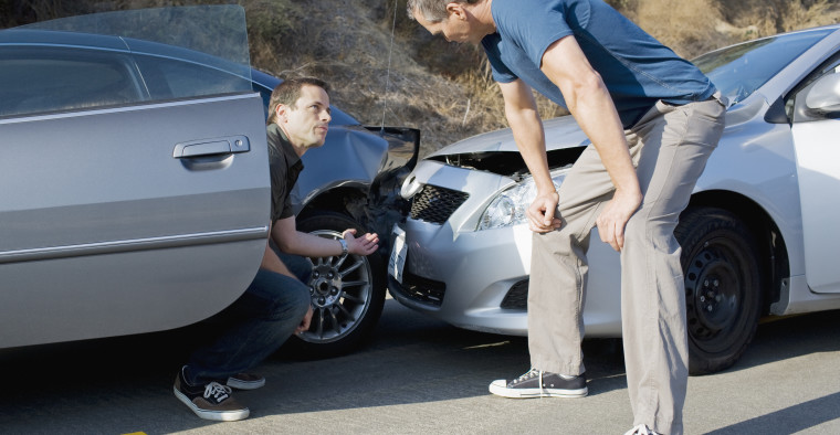 two drivers reviewing damage from accident
