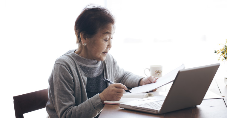 Senior woman writing a document and working at home
