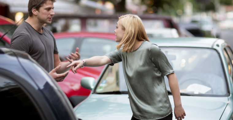 Man and woman arguing after a traffic accident