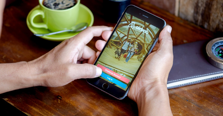 person booking Airbnb on phone