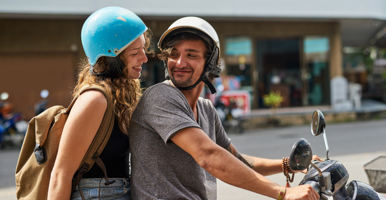 Backpackers riding a scooter