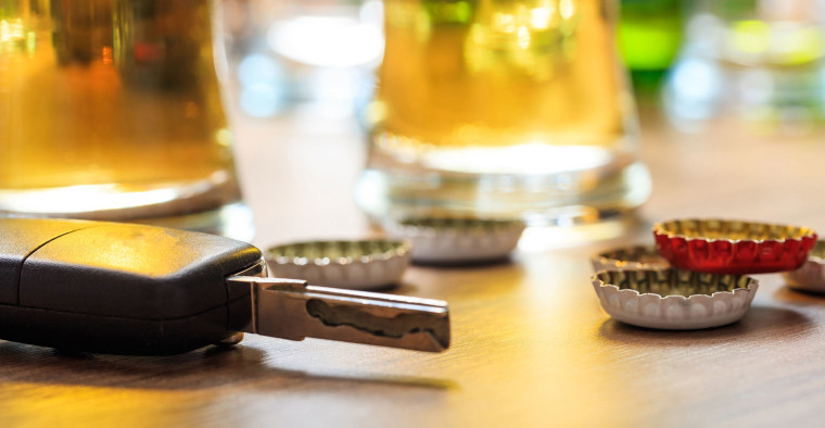 Set of car keys next to bottle caps.