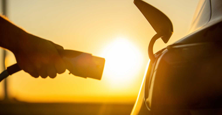 Electric car being plugged into a charging station.