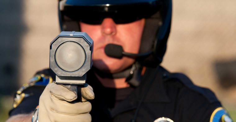 Officer using a speeding detection device.
