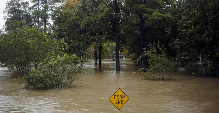A Dead End sign stands in floodwaters.