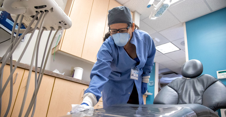 Dental assistant wiping down chair.