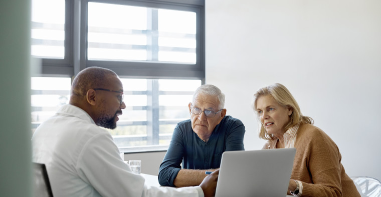 A doctor speaking with an elderly couple