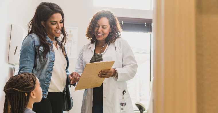 family at doctor using employee health insurance