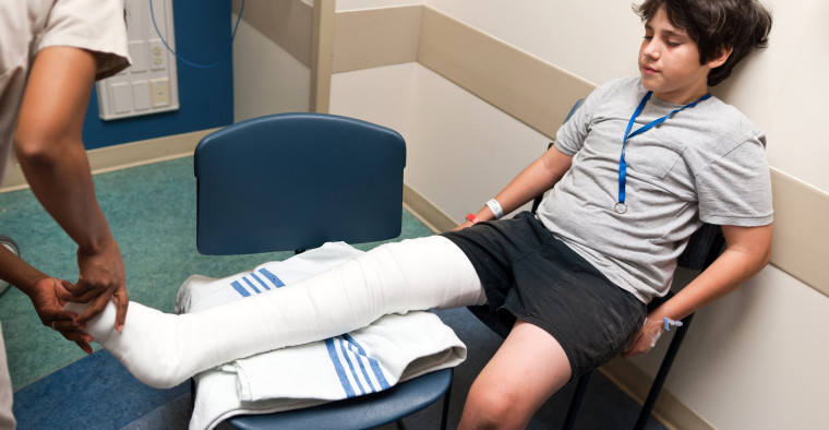 A nurse checks a child’s bandages.