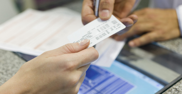 A man hands over a health insurance card.