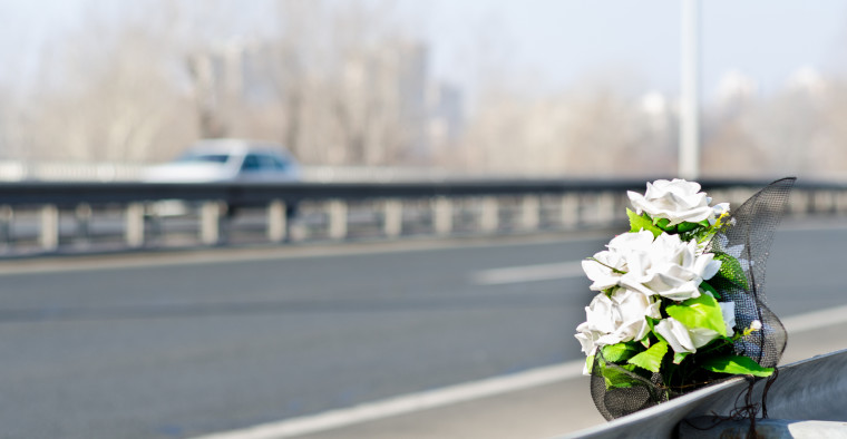 White roses at the site of a fatal car crash.