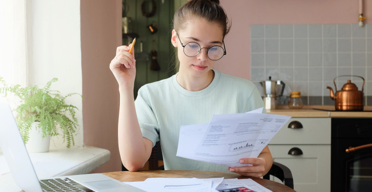 Indoor picture of young European female sitting at home at table