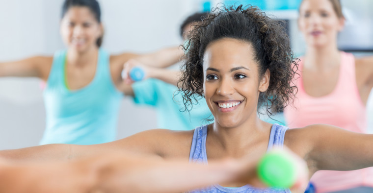 A woman participates in a weight training exercise class.
