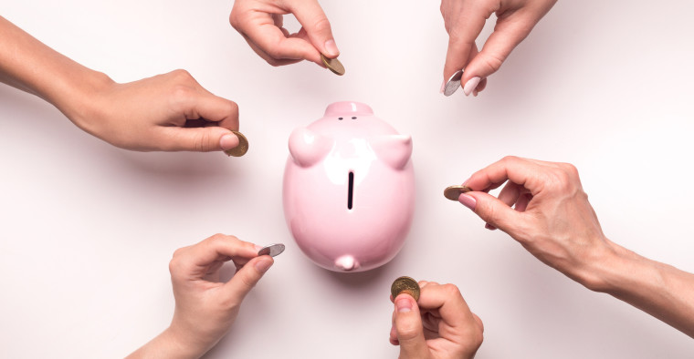Hands putting coins in a piggybank