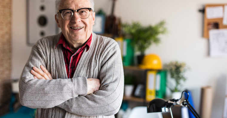 Happy senior man in his home office.