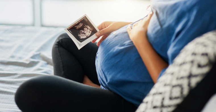 expecting mom holding sonogram
