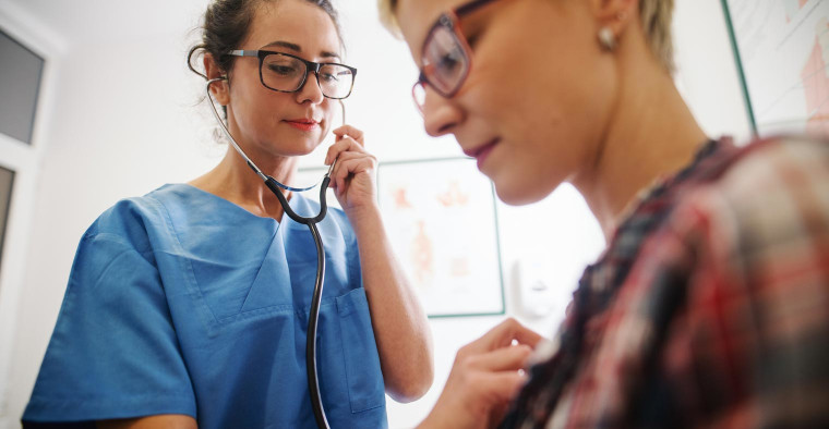 Nurse listening to a patient's heart with a stethoscope