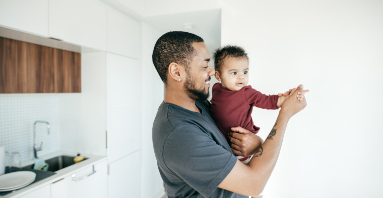 Father and newborn dancing.