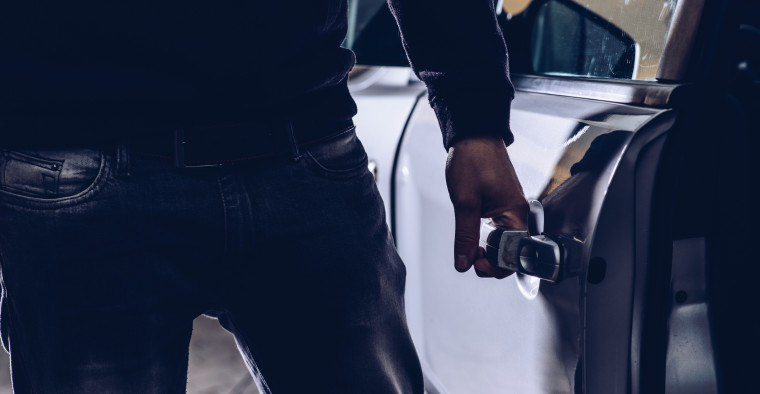 Man stealing a car at night