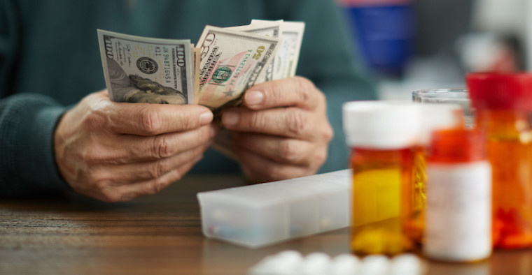 A man counts cash in front of his medications.