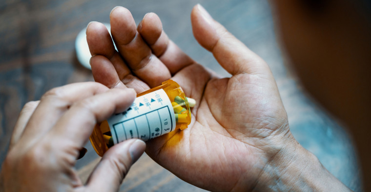 A man pours medication into his hand.