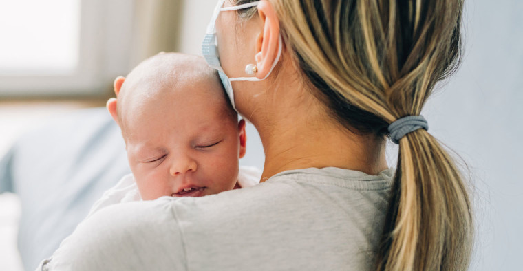 Mother with mask and newborn.
