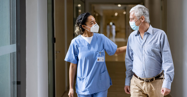 Nurse walking with an elderly patient.