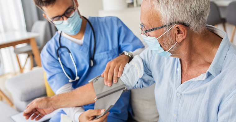 A nurse checks a patient’s blood pressure.