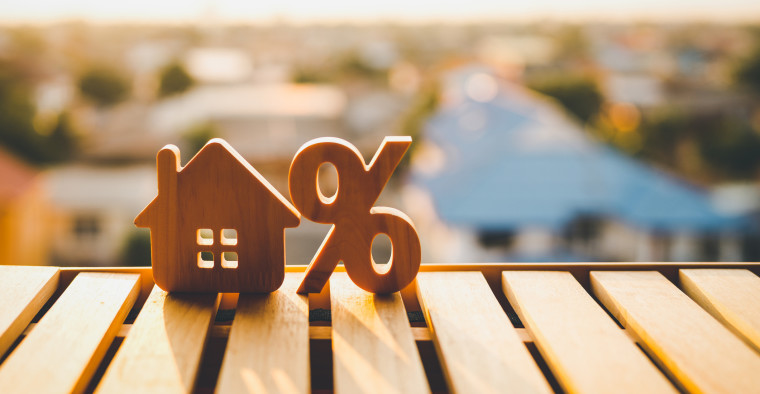 A percentage and house wooden sign