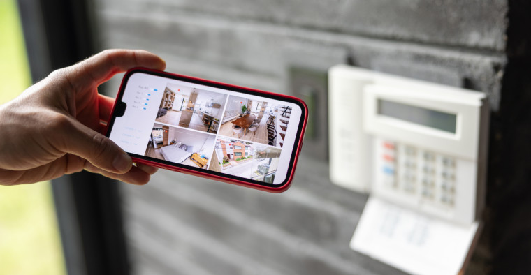 A woman watches the security cameras in her house.
