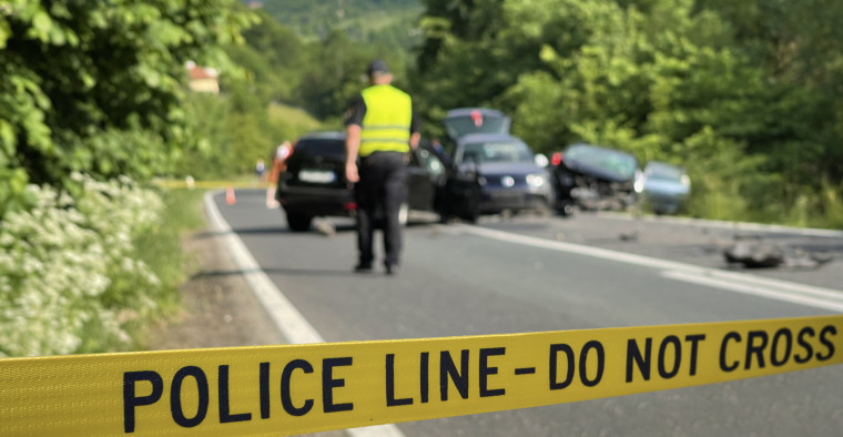 Police tape is shown at the scene of a car accident.