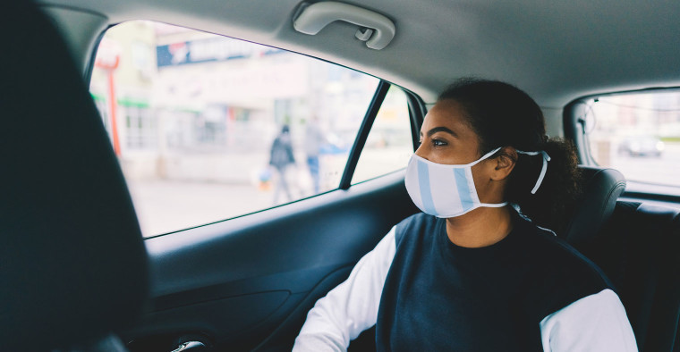 Masked passenger in a rideshare vehicle.