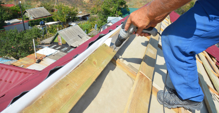 Roofer fixing a damaged home.