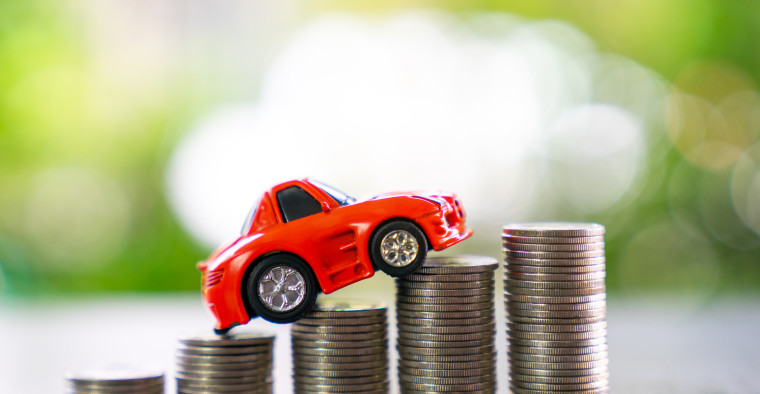 A model car sits on sets of coins.
