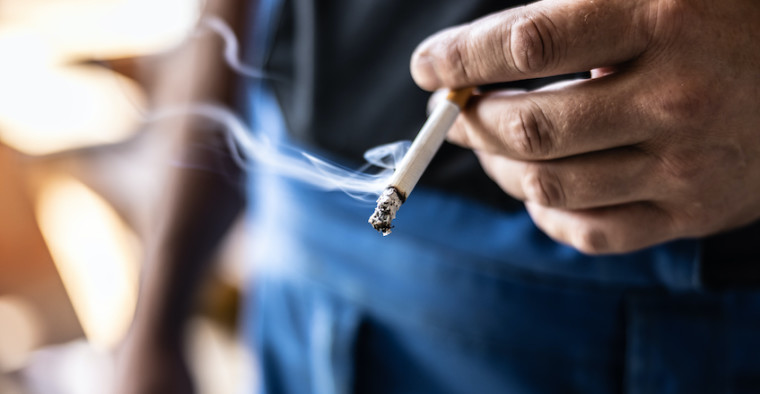A man holds a cigarette.