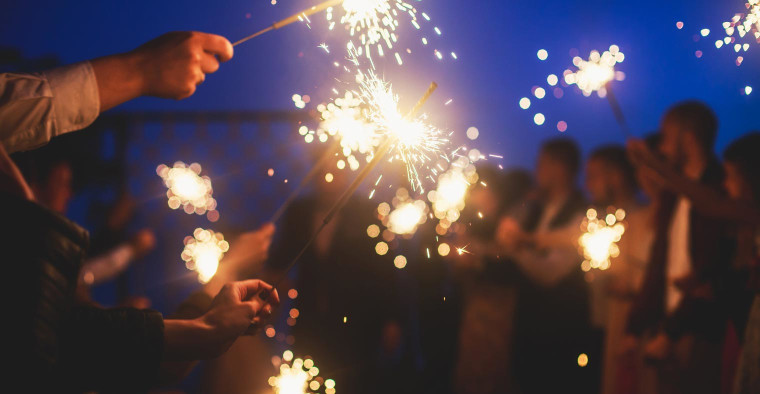 People celebrate with sparklers.